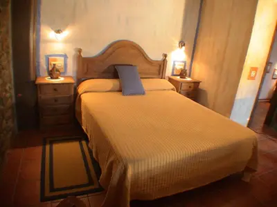 a bedroom with a bed with a blue pillow on it at Casa del Cura in Rozas