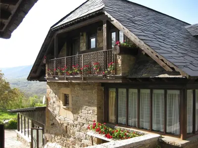 a house with a balcony with flowers on it at Casa del Cura in Rozas