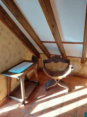 an attic room with a chair and a table at Casa del Cura in Rozas