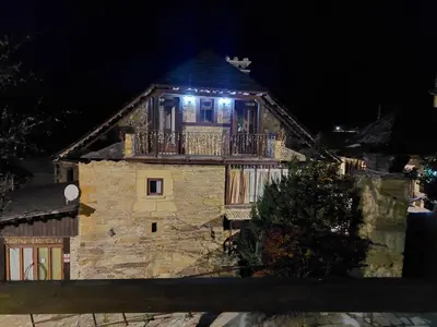 an old stone house with a balcony at night at Casa del Cura in Rozas