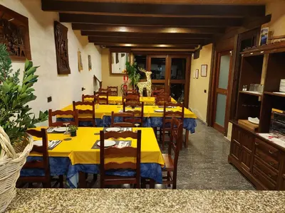 a long dining room with yellow tables and chairs at Casa del Cura in Rozas