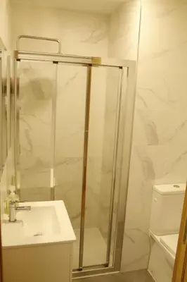 a bathroom with a glass shower and a sink at Pensión A Solaina in O Pedrouzo