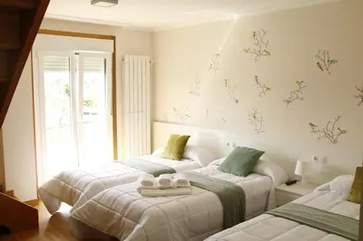 a bedroom with two beds and a window at Pensión A Solaina in O Pedrouzo