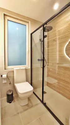 a bathroom with a toilet and a glass shower at Apartamento en el casco historico de Betanzos in Betanzos