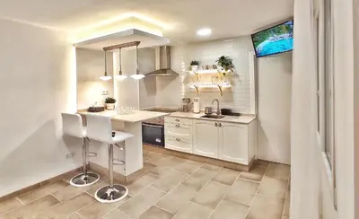 a white kitchen with a sink and a counter at Apartamento en el casco historico de Betanzos in Betanzos