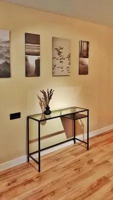 a glass table in front of a wall with pictures at Apartamento en el casco historico de Betanzos in Betanzos