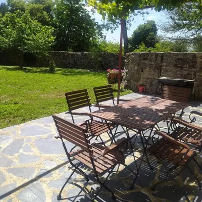 a picnic table with four chairs and an umbrella at Casas Quo Vadis -Azul in Lugo