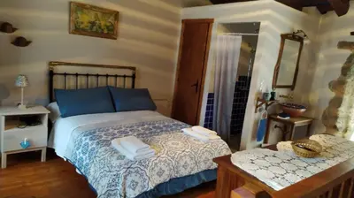 a person sitting on a couch in a room with a fireplace at Casas Quo Vadis -Azul in Lugo