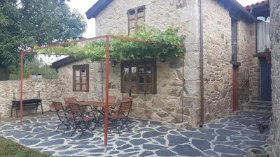 a table and chairs in front of a stone building at Casas Quo Vadis -Azul in Lugo