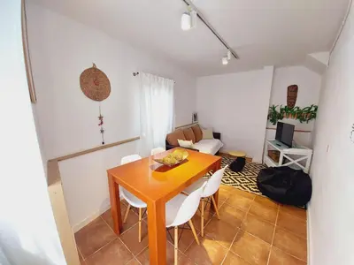 a dining room with a wooden table and white chairs at Casa Mencía in Camponaraya