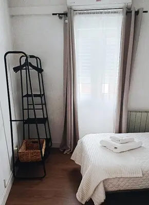 a bedroom with a bed and a ladder next to a window at Casa Mencía in Camponaraya