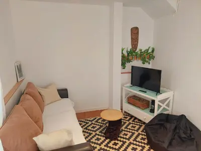 a living room with a couch and a tv at Casa Mencía in Camponaraya