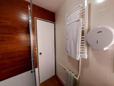 a bathroom with a white door and a towel at Casa Mencía in Camponaraya