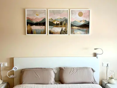 three paintings on the wall above a bed at Apartamento de Begoña in Barreiros