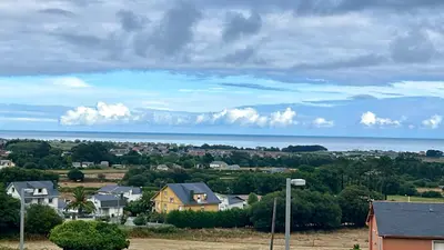 a town with houses and the ocean in the background at Apartamento de Begoña in Barreiros