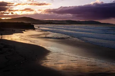 a view of a beach at sunset with the ocean at Apartamento de Begoña in Barreiros