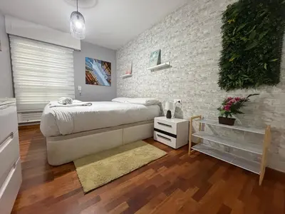a bedroom with a large bed and a brick wall at Oktheway Fonteculler in Culleredo