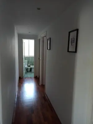 a hallway with white walls and wooden floors and a window at Oktheway Fonteculler in Culleredo