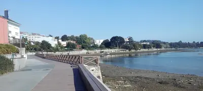 a wooden bridge over a river next to a beach at Oktheway Fonteculler in Culleredo