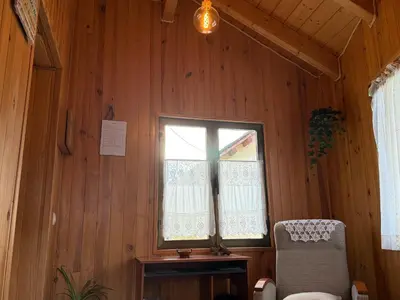 a room with a window with a chair and a table at La Casucha in Caboalles de Abajo
