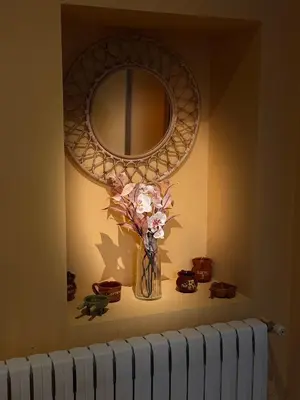 a vase of flowers on a shelf under a mirror at La Casucha in Caboalles de Abajo