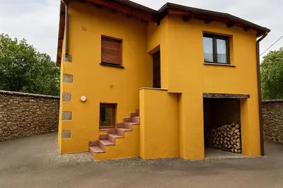 a yellow house with stairs on the side of it at La Casucha in Caboalles de Abajo
