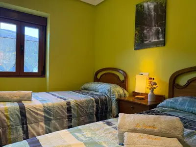 a yellow bedroom with a bed and a window at La Casucha in Caboalles de Abajo