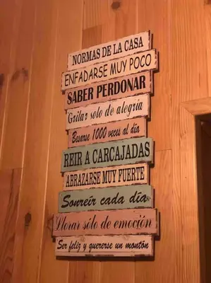a group of signs on a wooden wall at La Casucha in Caboalles de Abajo
