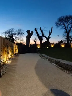 a walkway with trees in the background at night at HOTEL CASAS DA FORTALEZA Casa da Torre in Outeiro de Rei