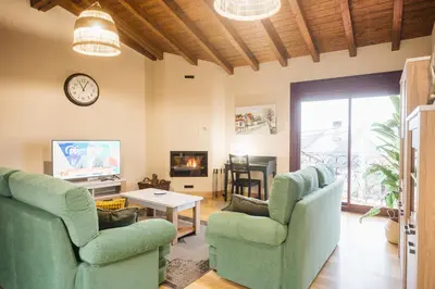 a living room with two chairs and a clock at Casa Sancristán. in Sober