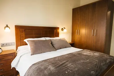 a bedroom with a large bed and wooden cabinets at Casa Sancristán. in Sober
