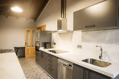 a kitchen with two sinks and a counter top at Casa Sancristán. in Sober