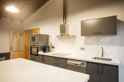 a kitchen with white marble counter tops and a sink at Casa Sancristán. in Sober