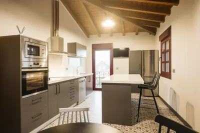 a kitchen with a counter and a table and chairs at Casa Sancristán. in Sober