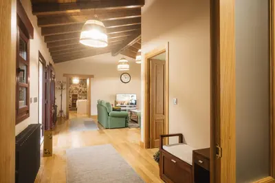 a living room with a green couch and a clock at Casa Sancristán. in Sober