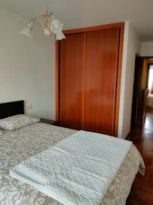 a bedroom with a bed and a wooden closet at Ciudad De Sada in Sada