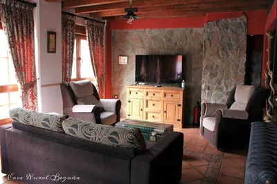 a living room with a couch and a flat screen tv at Casa Begoña in Igüeña