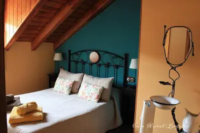 a bedroom with a bed with a mirror on the wall at Casa Begoña in Igüeña