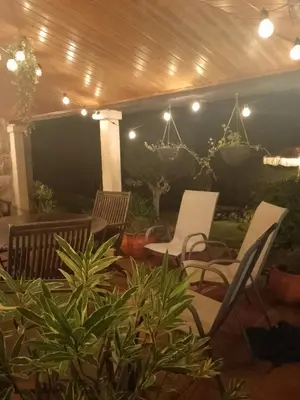 a patio with chairs and lights and plants at Casa rústica O NOSO VAL in Mondariz