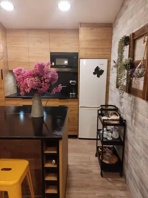 a kitchen with a refrigerator and a vase of flowers at Casa rústica O NOSO VAL in Mondariz