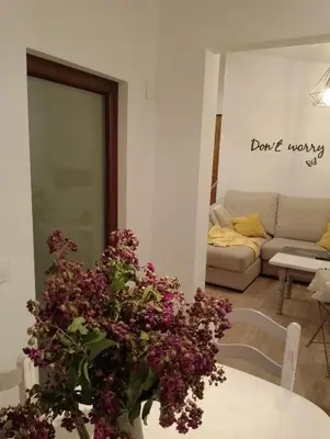 a living room with a table with purple flowers at Casa rústica O NOSO VAL in Mondariz