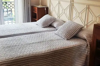 a bedroom with a bed with two pillows on it at Apartamento en el centro de FOZ in Foz