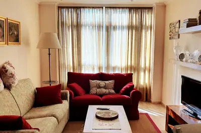 a living room with a red couch and a fireplace at Apartamento en el centro de FOZ in Foz