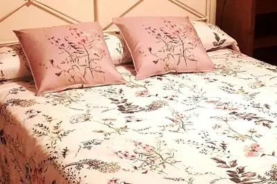 a bed with pink and white sheets and pillows at Apartamento en el centro de FOZ in Foz