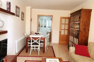 a living room with a table and a dining room at Apartamento en el centro de FOZ in Foz