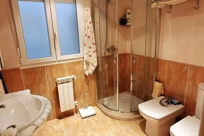 a bathroom with a shower and a toilet and a sink at Apartamento en el centro de FOZ in Foz
