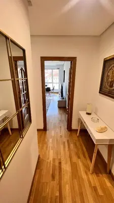 a living room with a wooden floor and a table at Apartamentos San Martin Ourense Centro 2 in Ourense
