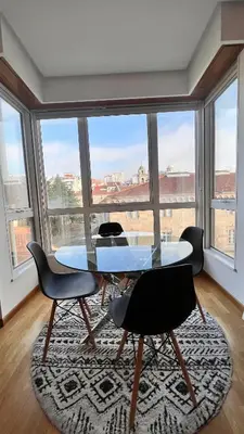 a glass table and chairs in a room with a large window at Apartamentos San Martin Ourense Centro 2 in Ourense