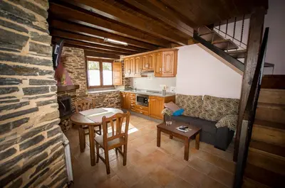 a kitchen and living room with a couch and a table at Apartamentos El Sualleiro in Santa Eulalia de Oscos