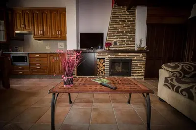 a living room with a table and a fireplace at Apartamentos El Sualleiro in Santa Eulalia de Oscos